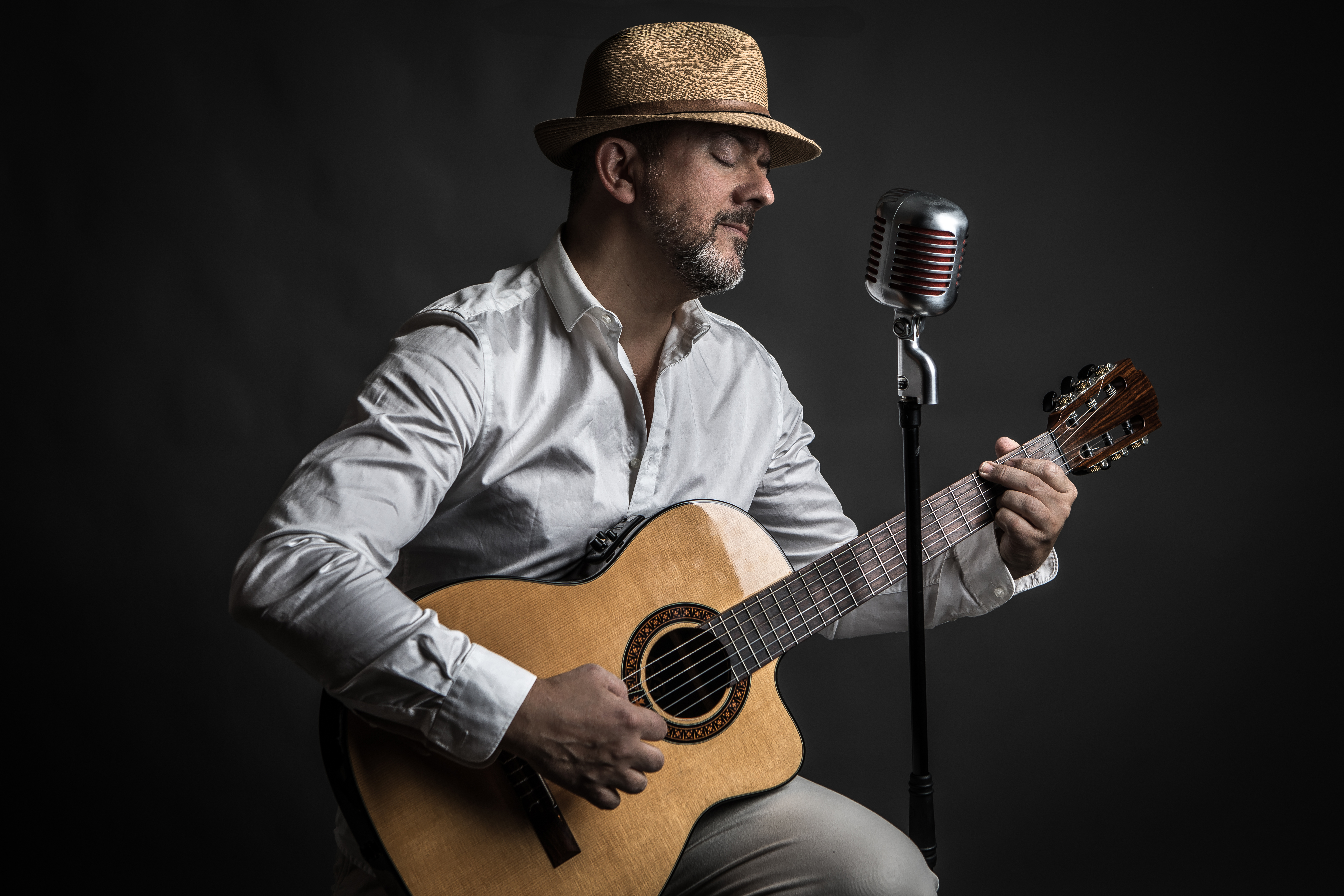 Marco Askraba jouant de la guitare et chantant